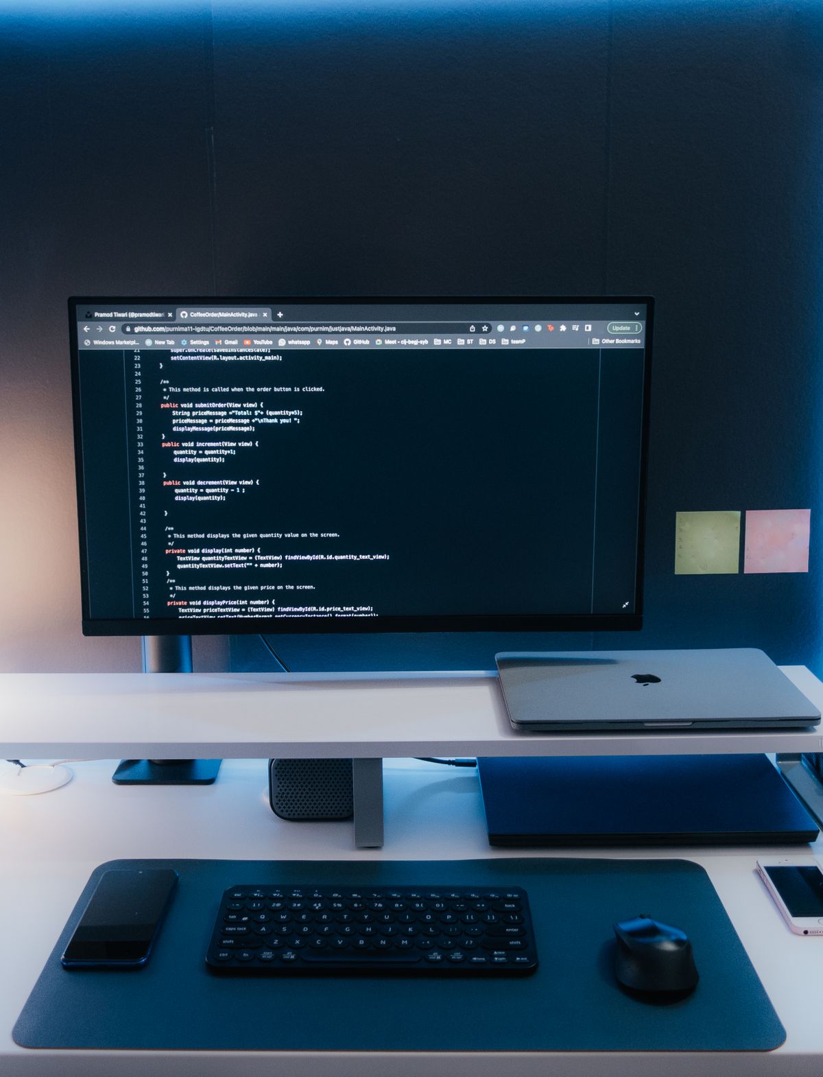 A clean, ordered workstation with code on a single wide monitor