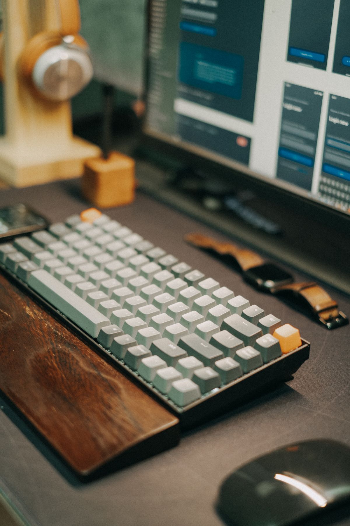 A tidy desk with a chat interface on screen and headphones on a stand