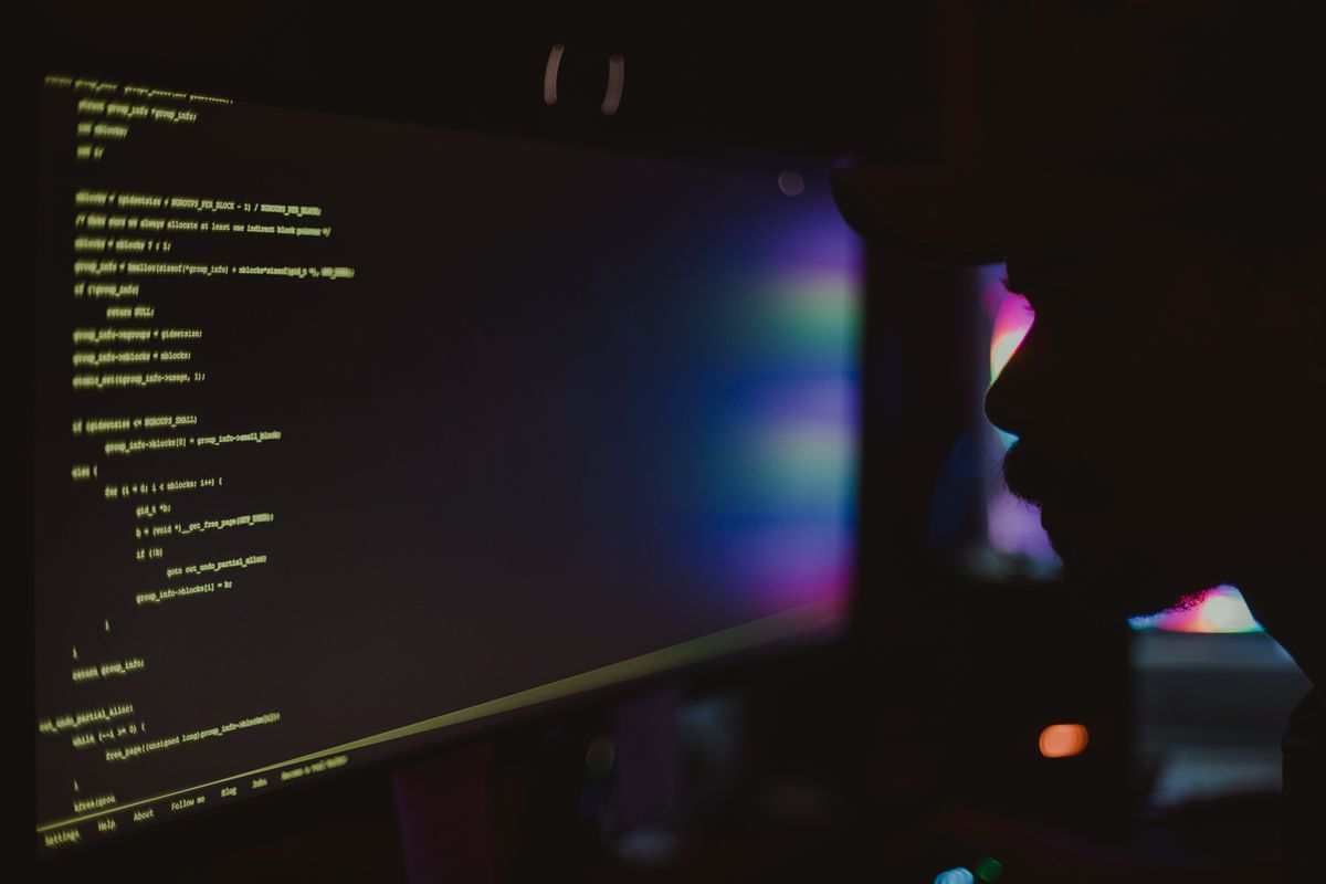 Late-night screen of code lighting a dark room